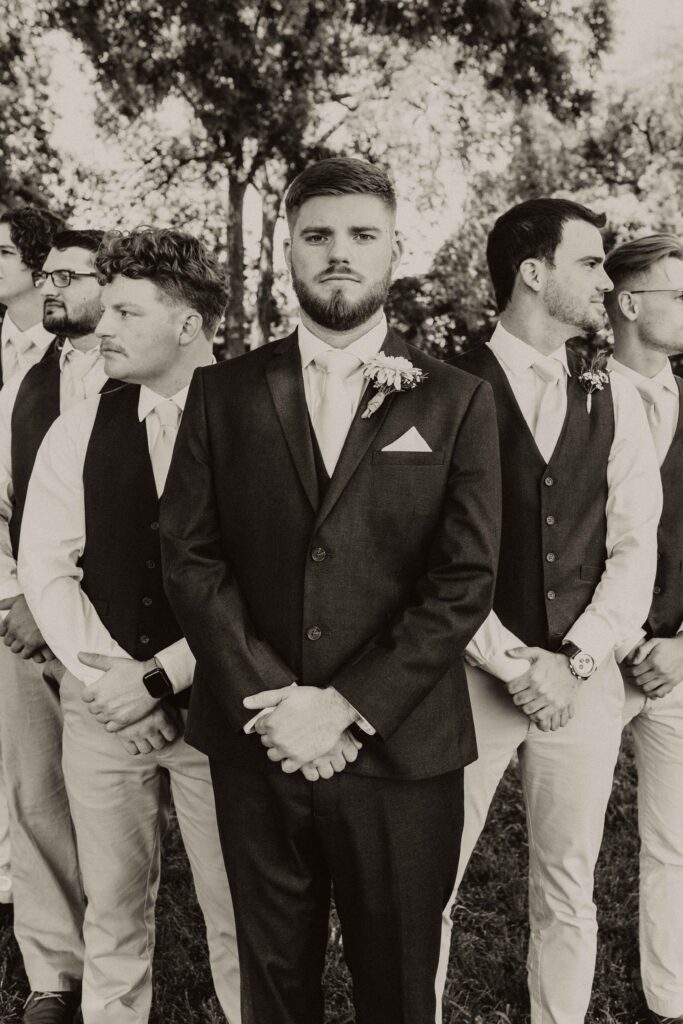 Groom posed in a fanned V with groomsmen.
