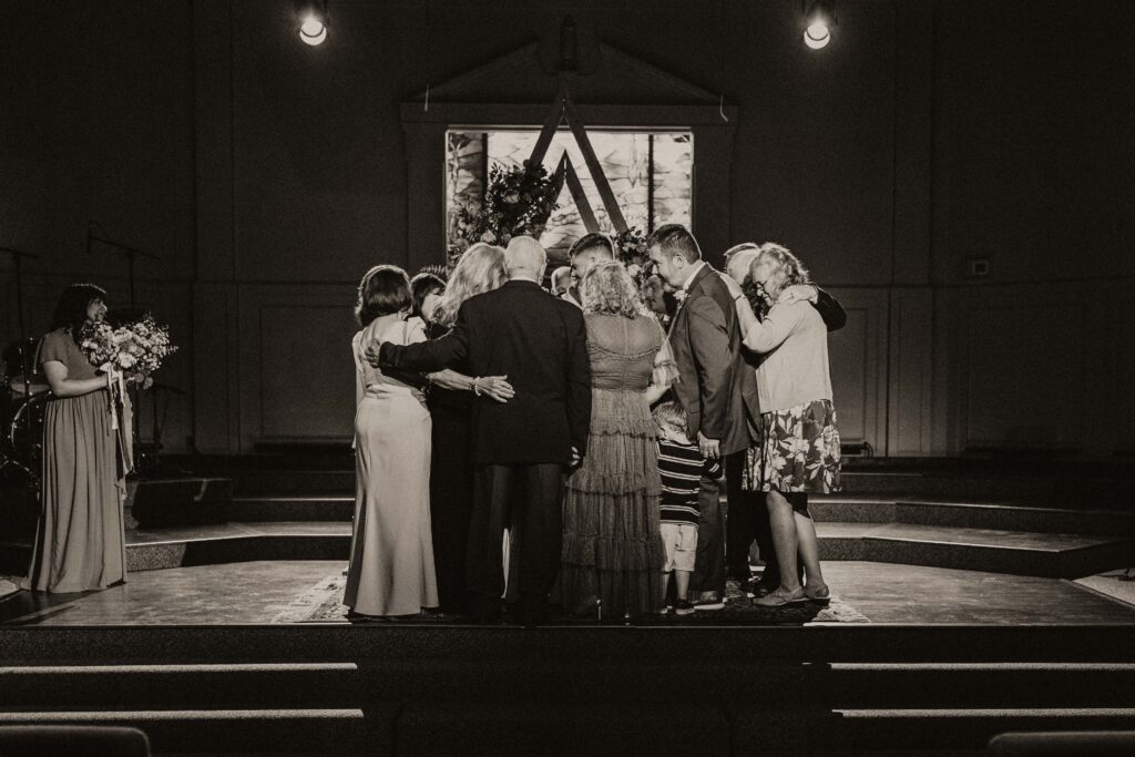 The bride and groom's family is called on stage for a final time of prayer over the couple.