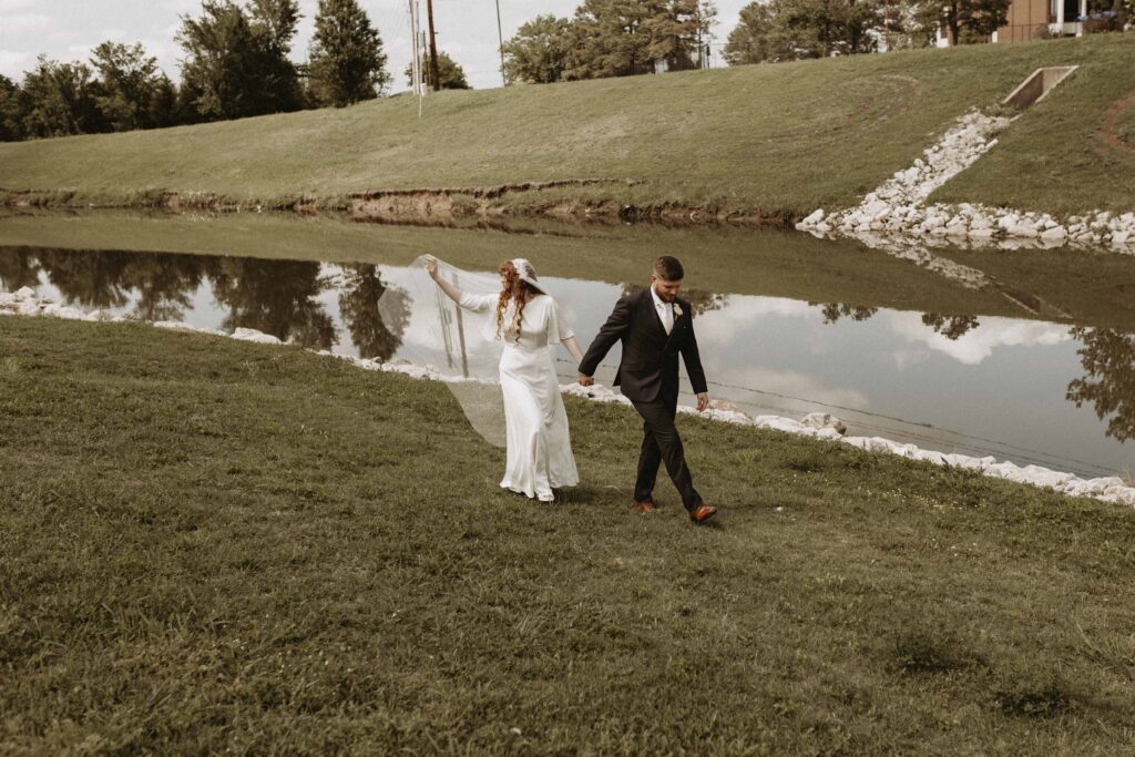 Newlywed photos down by a stream of water.