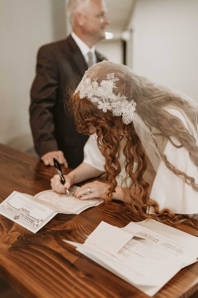 The bride signs her marriage document after the ceremony.