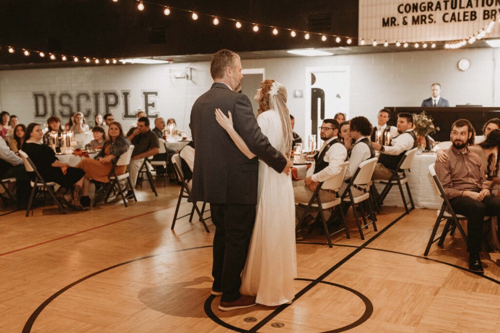 Father and daughter dance at wedding reception.