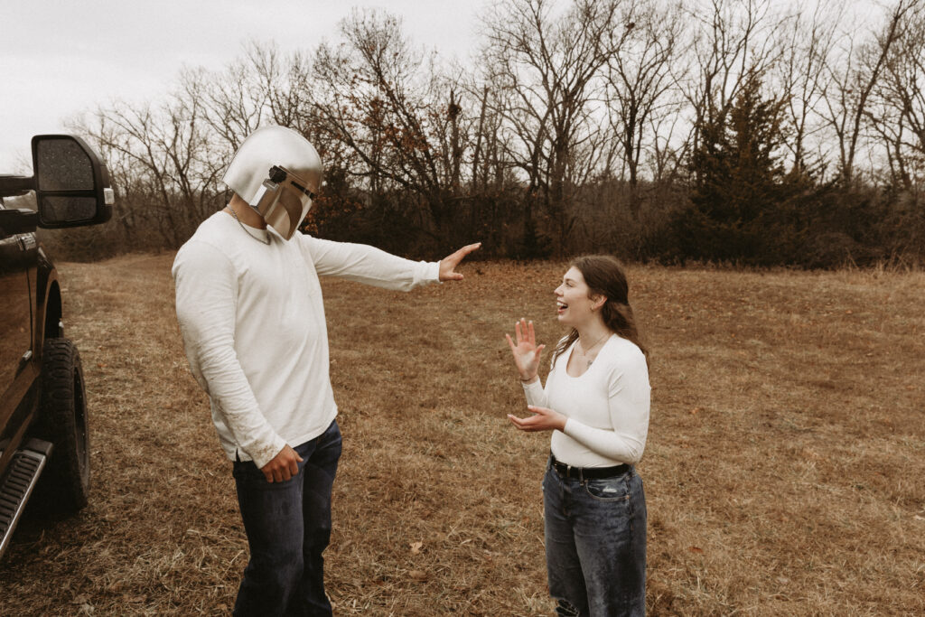 Young man uses the force on his girlfriend with his Star Wars mask.