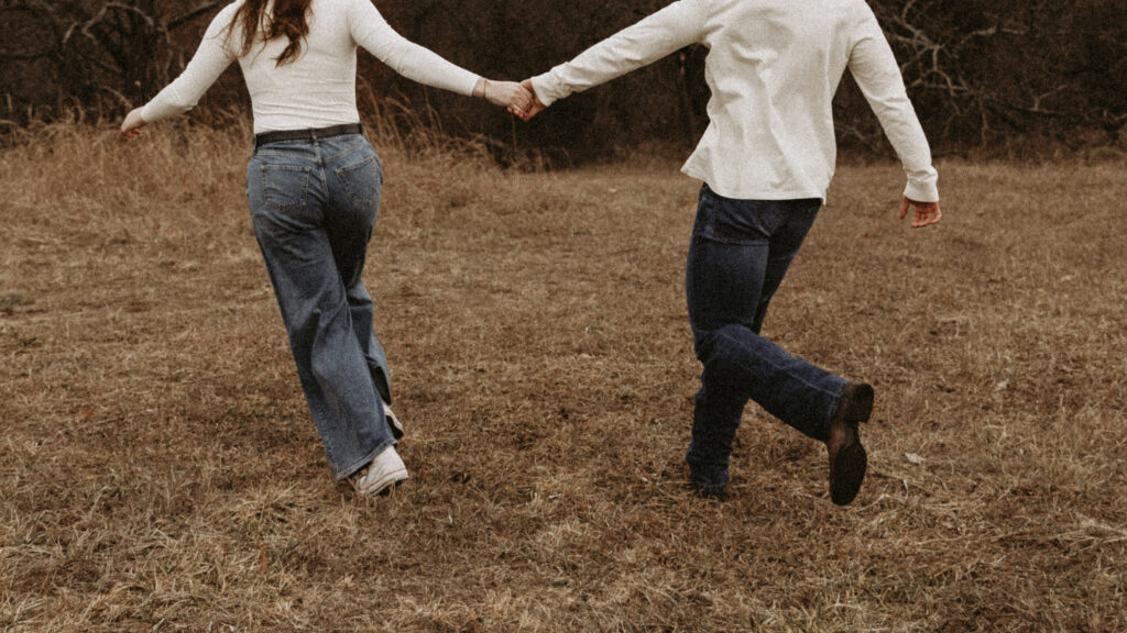 Accent photo of couple holding hands and running.