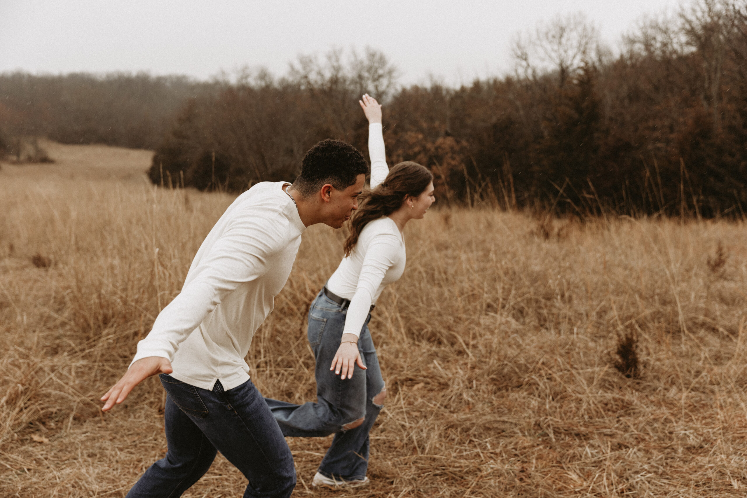 Young couple soars like birds in open field.