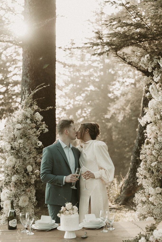 Bride and groom toast over champagne at their dinner table for their dreamy Crook Point elopement in Oregon.