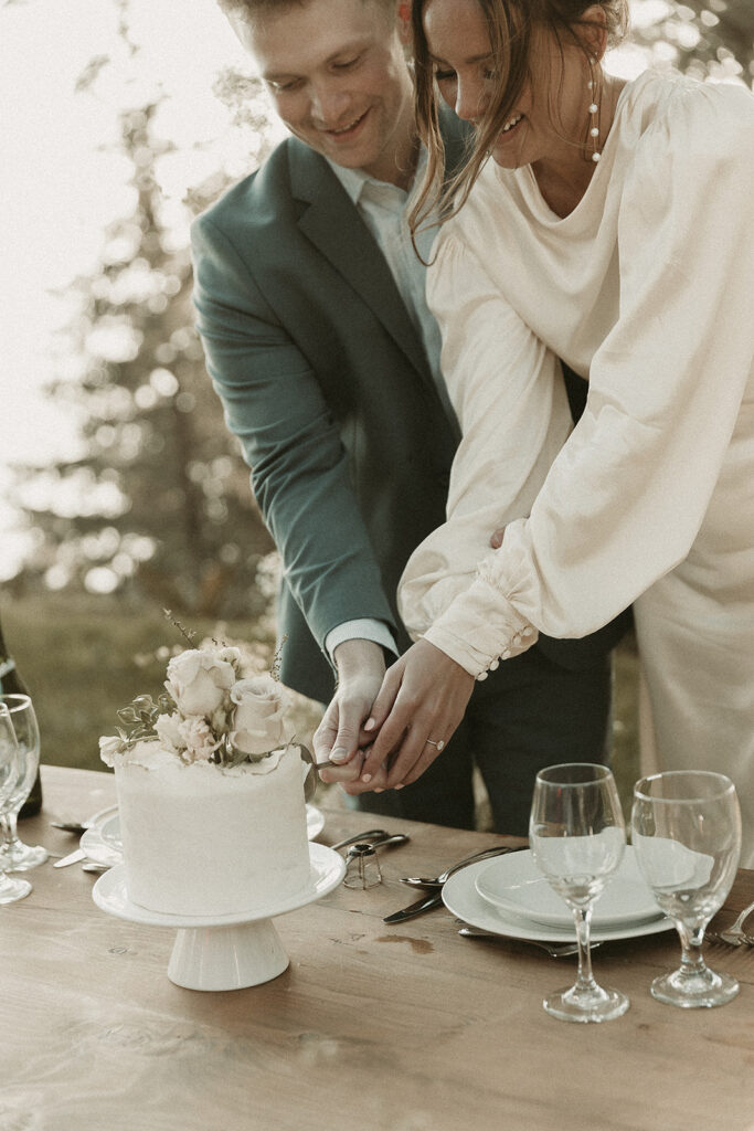 Bride and groom cut into a cake at their dreamy Crook Point elopement in Oregon.