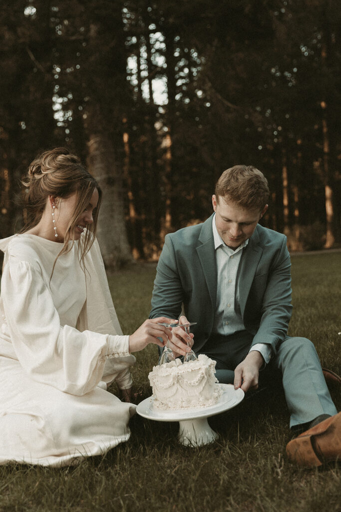 Bride and groom cut into a cake at their dreamy Crook Point elopement in Oregon.