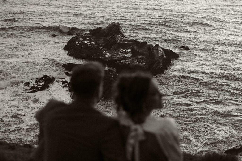 Bride and groom admire scenic views during dreamy sunset cliff elopement photos at Crook Point, Oregon.