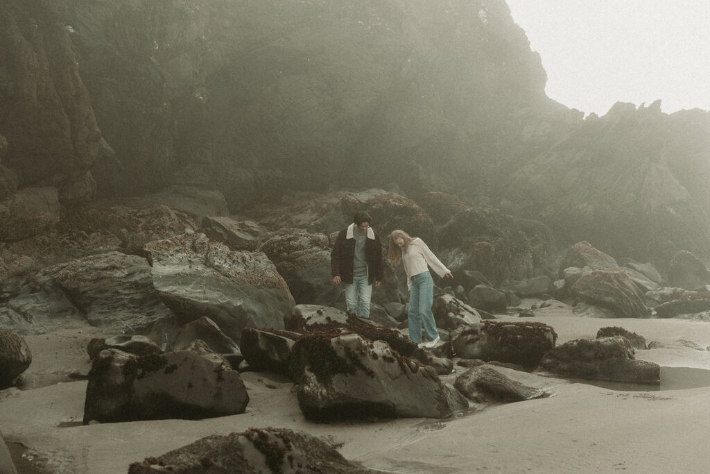 Young couple explores sea stack at Gold Beach, Oregon.