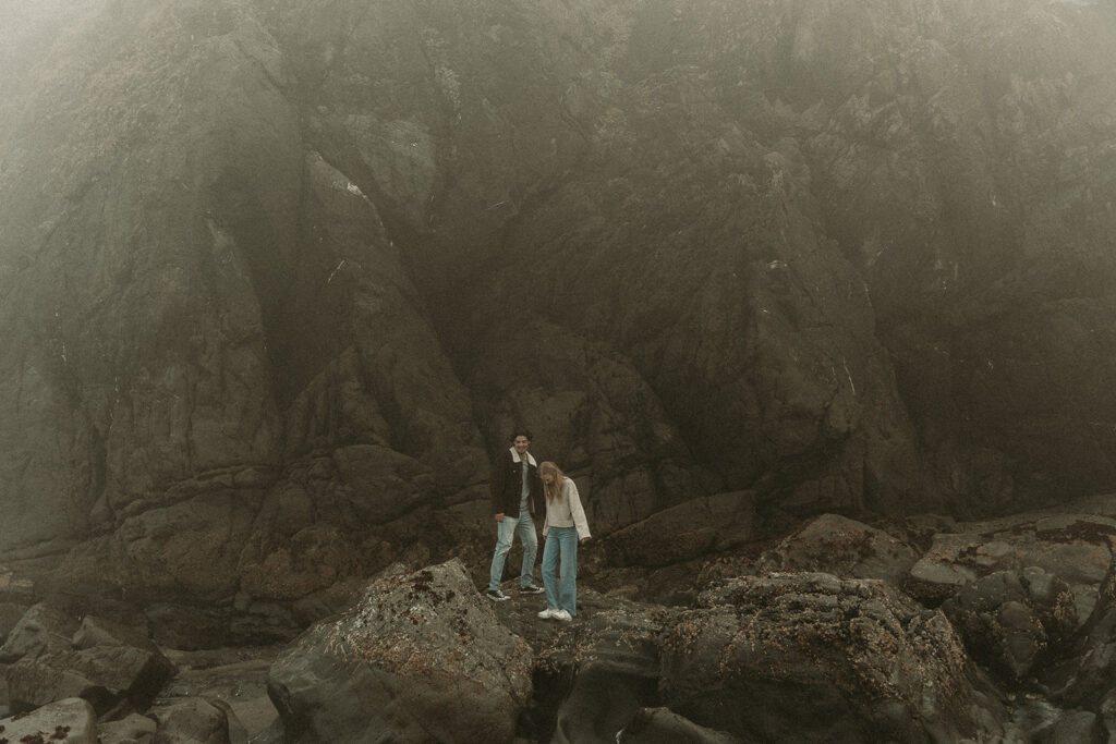 Young couple explores sea stack at Gold Beach, Oregon.