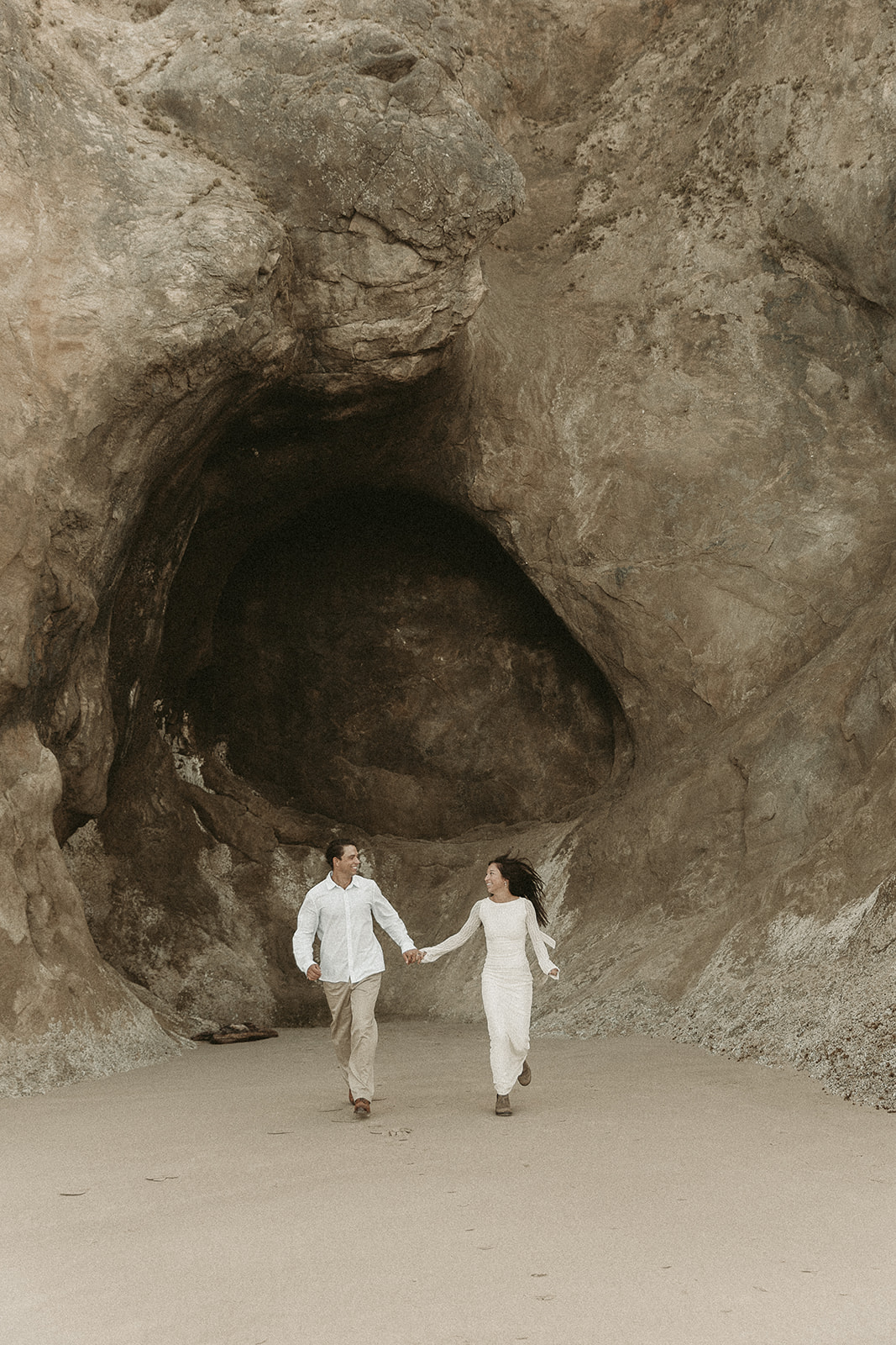 Couple explores Hug Point during their Oregon coast elopement.