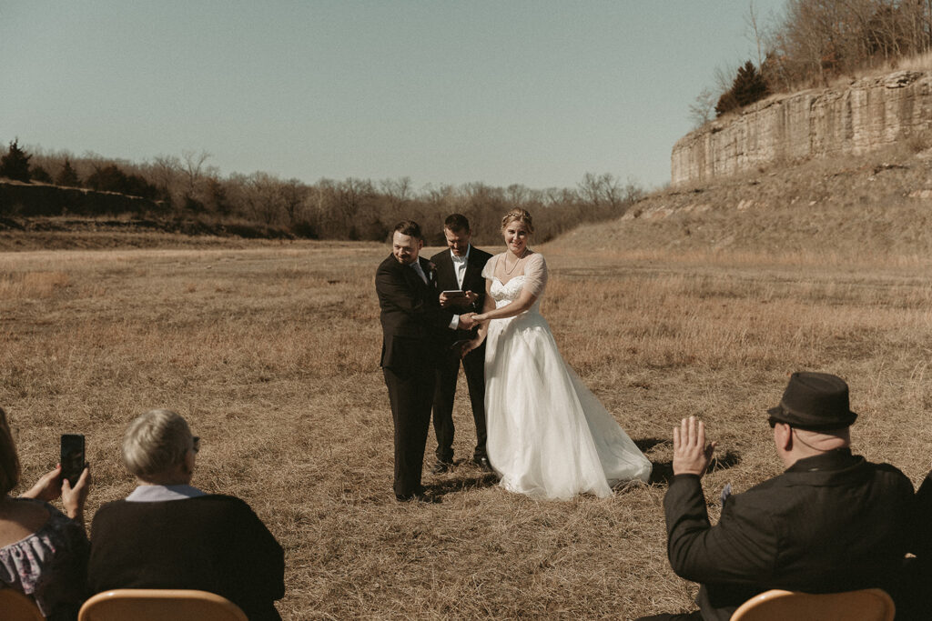 Spring micro wedding at Blue Springs Lake, Missouri. Couple looks out at their witnesses.