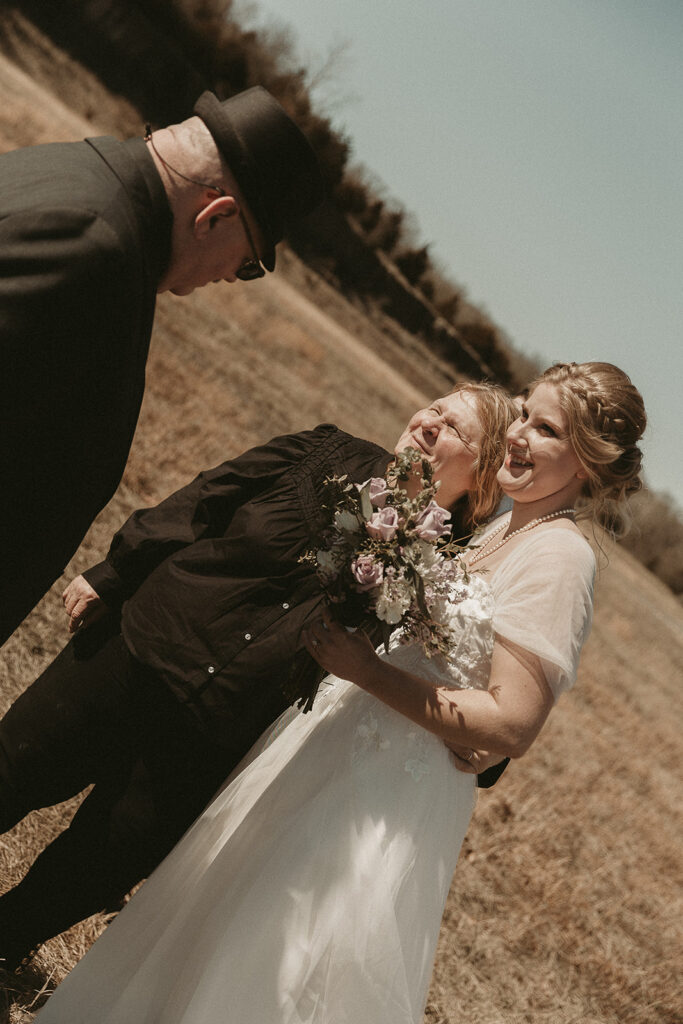 Spring micro wedding at Blue Springs Lake, Missouri. Bride hugs groom's family.